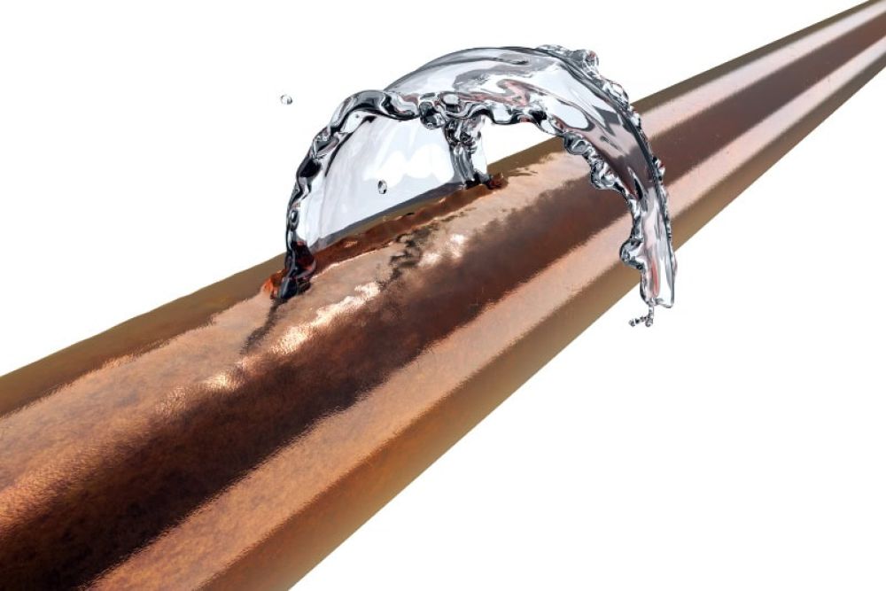 Copper pipe with water splash demonstrating plumbing dynamics and flow efficiency.